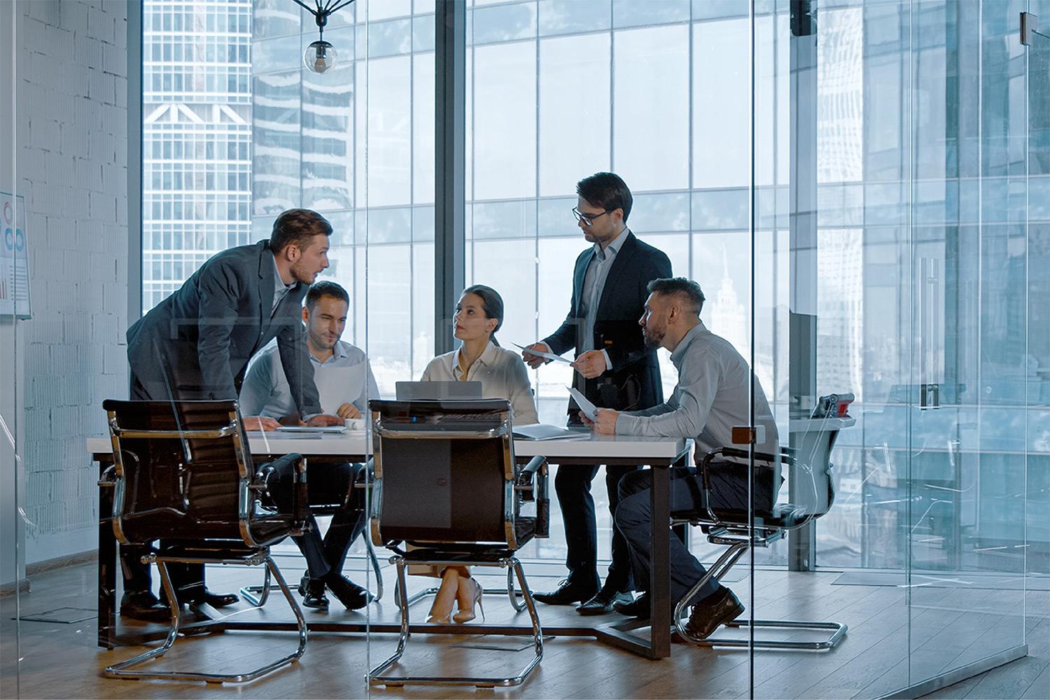 An image of a group of people gathered round a desk collaborating on a project.