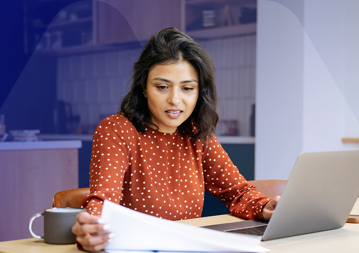 A person reviews documents while using a laptop at home, reflecting the growing interest in pensions dashboards. Dashboards are still in development and not yet available to the public. Find updates, guidance and support through the Money and Pensions Service and Pension Wise.